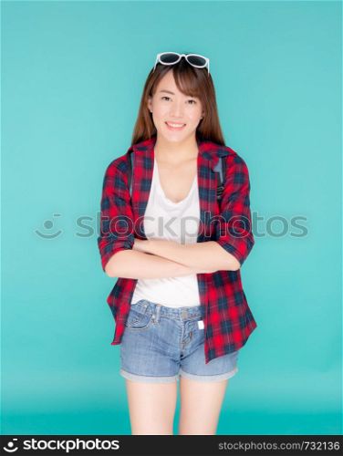 Beautiful portrait young asian woman wear sunglasses on head smile expression confident enjoy summer holiday isolated blue background, model girl fashion having backpack, travel concept.