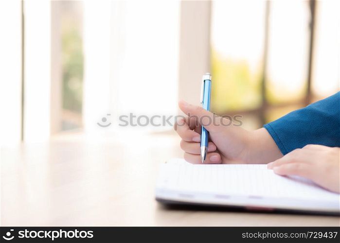 Beautiful portrait young asian woman writer smiling thinking idea and writing on notebook or diary with happy, lifestyle of asian girl is student, female planning working, education and business concept.