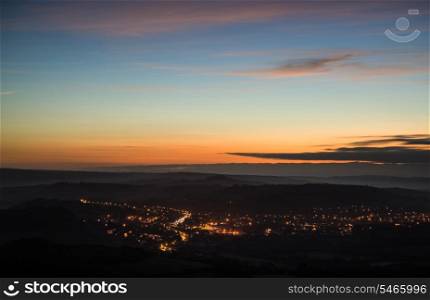 Beautiful pre-dawn landscape overlooking lights of town in valley