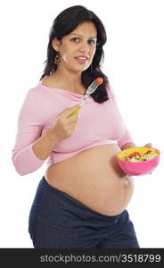 Beautiful pregnant eating salad on a over white background