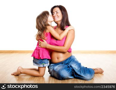 Beautiful pregnant mother with her daughter isolated on white