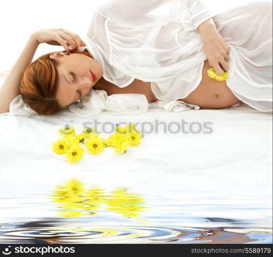 beautiful pregnant redhead woman with yellow flowers