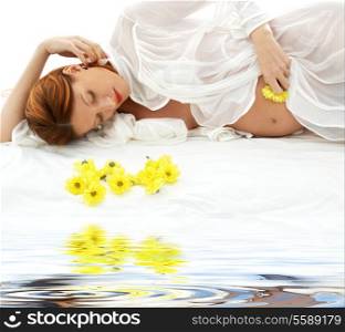 beautiful pregnant redhead woman with yellow flowers