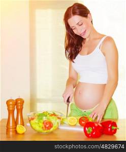 Beautiful pregnant woman cooking salad on the kitchen at home, healthy nutrition, cutting vegetables, happy and healthy pregnancy concept