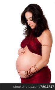 Beautiful pregnant woman dressed in red with bindi on forehead holding her belly and looking down, isolated