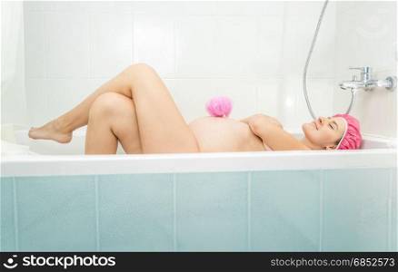 Beautiful pregnant woman lying in bath