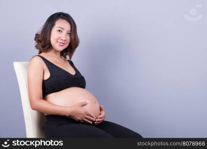 Beautiful pregnant woman on gray background