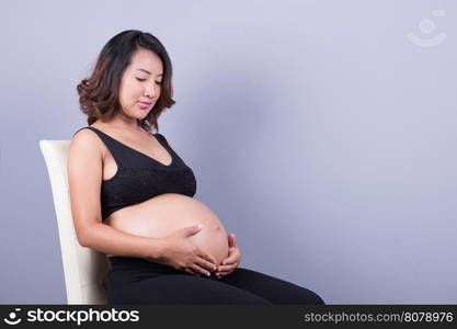 Beautiful pregnant woman on gray background