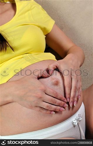 Beautiful pregnant woman relaxing on couch