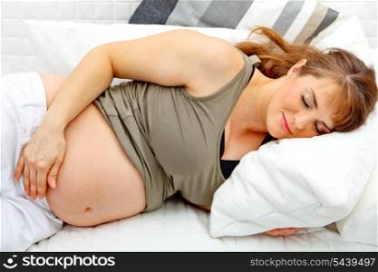 Beautiful pregnant woman sleeping on sofa at home &#xA;