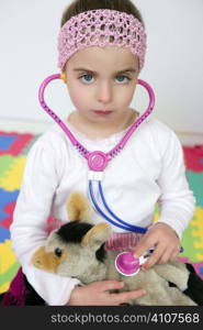 Beautiful preschooler girl pretending to be an animal doctor, stethoscope