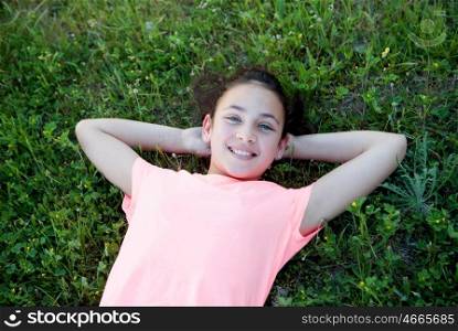 Beautiful preteen girl with blue eyes lying on the grass