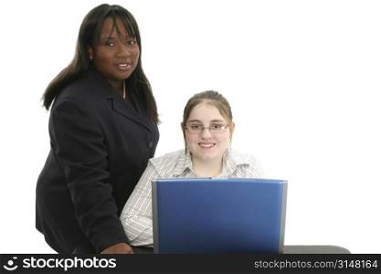 Beautiful professional looking woman in suit helping happy teen at the laptop.