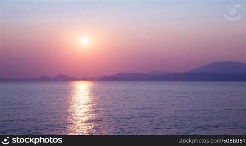 Beautiful purple sunset on the sea, sun reflection on peaceful water, wonderful landscape, scene destination, beauty of nature concept