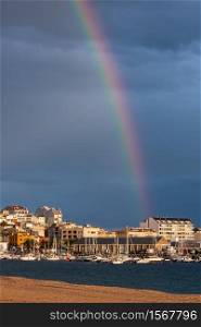 Beautiful rainbow over small town (Palamos) in Spain