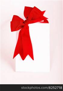 Beautiful red bow over blank greeting card, holiday concept