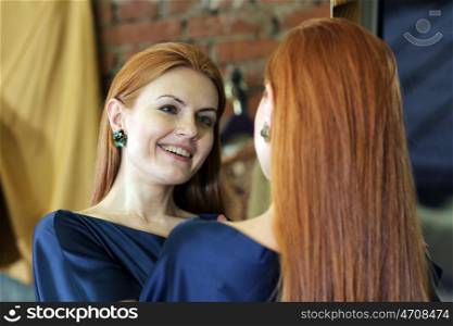 beautiful red-haired woman posing in front of a mirror