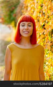 Beautiful red haired woman with closed eyes in a park lit with a golden light