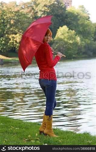 beautiful red-haired woman with red umbrella and red pullover