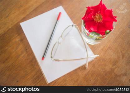 Beautiful red rose on work table, stock photo