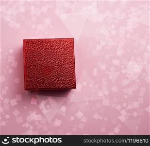 beautiful red shiny closed box on a pink background, concept of congratulations and surprise, top view