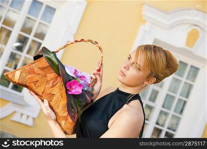 Beautiful redhead girl with a floral handbag