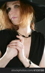 beautiful redhead woman in black with hat and jewels