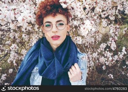 Beautiful redhead woman surrounded by flowers