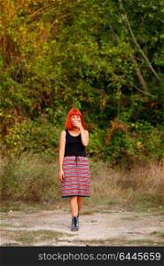 Beautiful redhead woman with a beautiful skirt relaxed outside