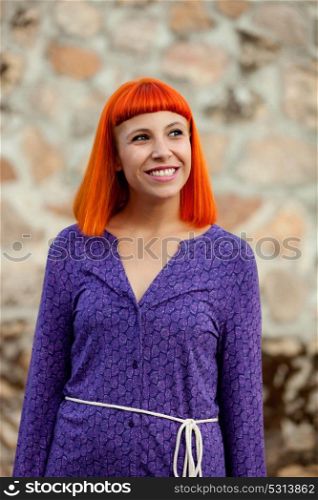 Beautiful redhead woman with a purple dress relaxed outside