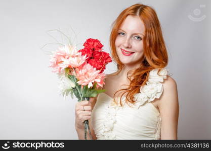 Beautiful redheaded girl with flowers studio shot