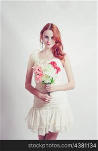 Beautiful redheaded girl with flowers, studio shot, toned cross processed colors