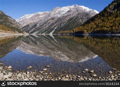 Beautiful reflection in lake Livigno in the Italian Alps. Lake Livigno in Italy