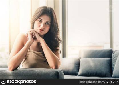 Beautiful relaxed business woman sitting on sofa couch in highrise office building tower.