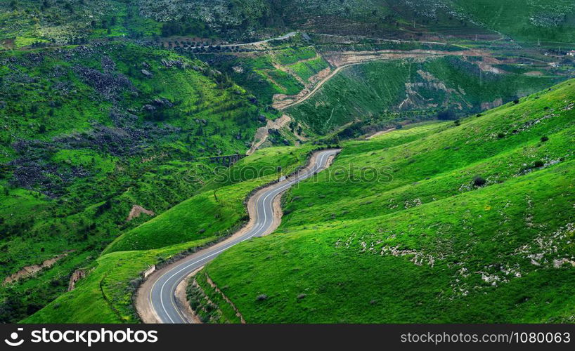 Beautiful road in Israel on the border with Jordan. Beautiful green hills and road. Golan Heights.