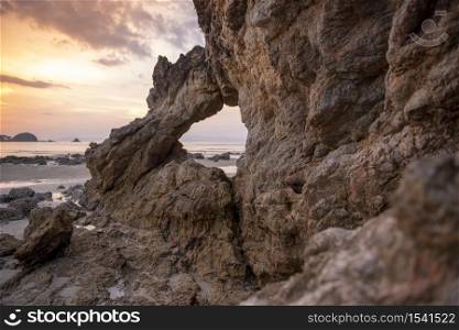 Beautiful rock on beach at sunset