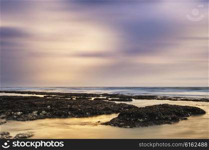 Beautiful rocky beach sunset landscape long exposure