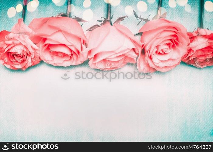 Beautiful romantic roses border on blue background with bokeh in pastel pale color
