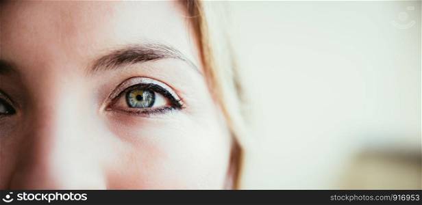 Beautiful rouged blue eye of a young girl, closeup and text space