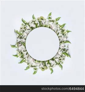 Beautiful round circle floral frame or wreath layout with green flowers on white background, top view