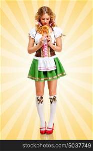 Beautiful sad sexy Oktoberfest woman wearing a traditional Bavarian dress dirndl holding a pretzel in hands on colorful abstract cartoon style background.