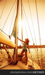 Beautiful sailor girl, pretty woman on the standing on yacht deck, warm sunset light, sailing sport, recreation on the sea, romantic summer holidays