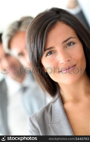 Beautiful saleswoman standing with group of business people