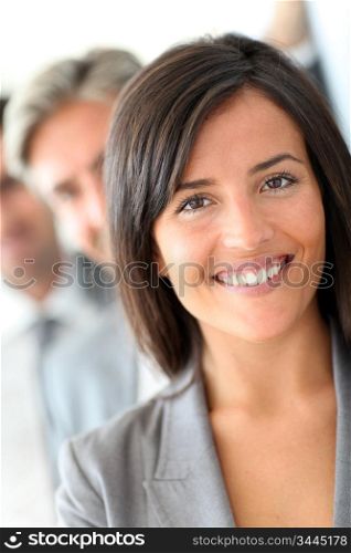 Beautiful saleswoman standing with group of business people