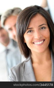 Beautiful saleswoman standing with group of business people