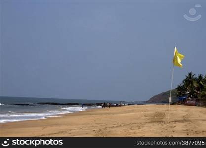 Beautiful sandy beach with a yellow flag. India Goa.. Beautiful sandy beach with a yellow flag. India Goa