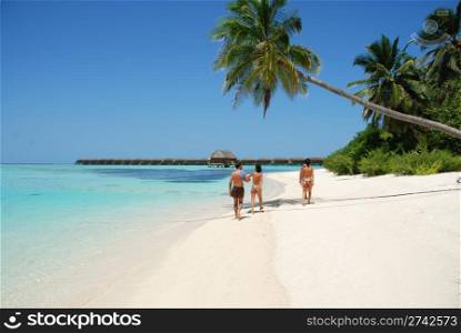 beautiful scene with a family walking by the beach in Maldives