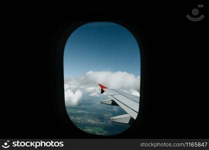 Beautiful scenic city view of sunset through the aircraft window. Image save-path for window of airplane.. View from window flight on air with flight wing with beautiful blue sky and cloud