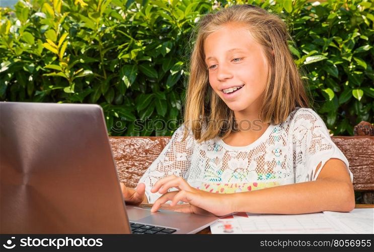 Beautiful schoolgirl,10 years old,happiness studying on the computer