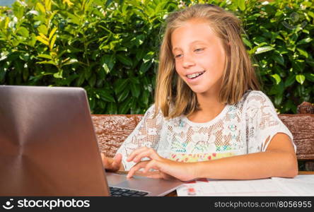 Beautiful schoolgirl,10 years old,happiness studying on the computer